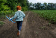 © Westend61 - Redhead boy holding toy airplane and running on dirt road near field
