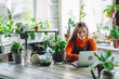 © Westend61 - Smiling botanist working on laptop at plant store