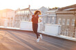 © Dasha Petrenko - Full-length of young carefree african american woman jumping at rooftop in morning sunlight