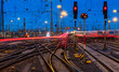 © ON-Photography - Blue hour at the main station of Frankfurt Main Germany with railway infrastructure technology, signals, crossings, catenary, glistening tracks, switches at twilight. Blurred train lights in motion.