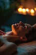 A woman relaxing on a massage table with a soothing ambiance created by the flickering candles. Perfect for promoting relaxation and self-care
