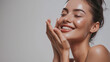 © ND STOCK - Skincare. Woman with beautiful face touching healthy facial skin. Woman smiling while touching her flawless glowy skin with copy space for your advertisement, skincare