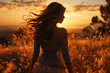 Young woman with long hair fluttering in the wind at sunset the sun in the field with her back