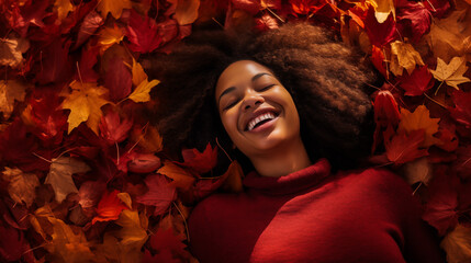 A woman lying on her back in a pile of red autumn leaves