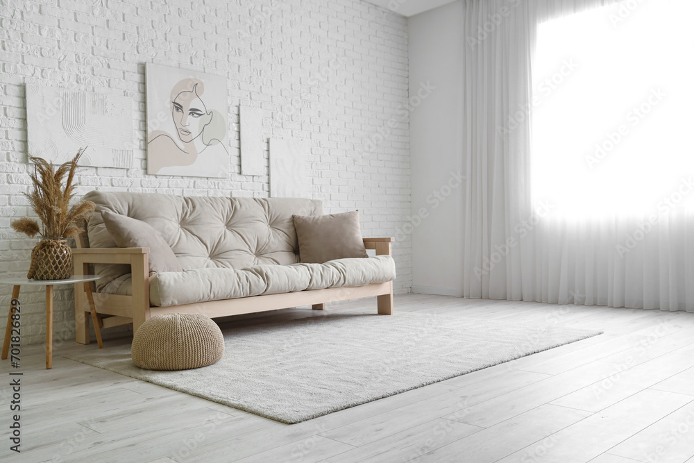 Cozy sofa with cushions in light living room