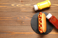 Board With Tasty Hot Dog, Ketchup And Mustard On Wooden Background