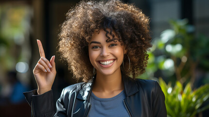 Wall Mural - Portrait of attractive and positive young afro woman pointing finger up