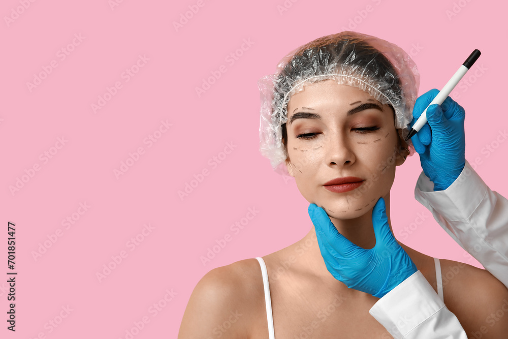 Plastic surgeon marking woman's face on pink background, closeup