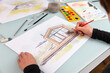 Architect illustrator working on hand drawn illustration of a modular prefabricated house  using watercolor paints and brush.