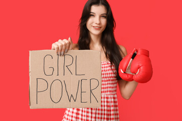 Wall Mural - Young woman with sign GIRL POWER and boxing gloves on red background. Feminism concept