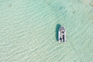 Wall Mural - Sea background texture. Aerial drone view of inflatable boat in Elafonisi island water Greece. Space