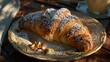 Freshly baked croissant with almonds on a wooden table.
