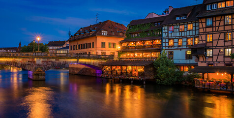 Sticker - Ornate traditional half timbered houses with blooming flowers along the canals in the Petite France district of Strasbourg, Alsace, France at sunset