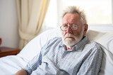 Fototapeta Konie - Sick elderly man with glasses and beard laying in bed.