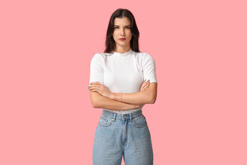 Wall Mural - Confident young woman with crossed arms on pink background. Feminism concept