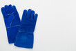 © Liami - Blue construction gloves on color background, top view
