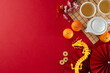 Engaging in the chinese New Year tea ceremony tradition. Top view photo of teapot, cups of tea, tangerines, gold dragon, decorative elements on red background with promo area