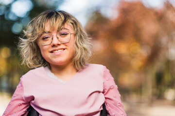 Young woman with cerebral palsy disability on wheelchair greeting and smile. Social inclusion