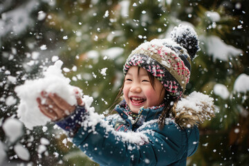 Wall Mural - Happy kid wearing warm clothes plays outdoors with snow in winter.