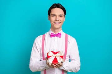 Canvas Print - Photo portrait of handsome young guy hold heart gift box ribbon wear trendy pink garment isolated on cyan color background