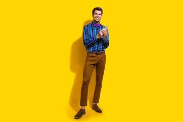 Sticker - Full size photo of intelligent guy dressed striped shirt trousers hold smartphone read notification isolated on yellow color background