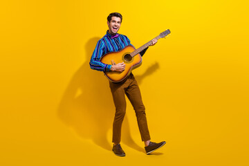 Canvas Print - Full body photo of positive chereful man with bristle wear vintage bow tie singing song play on guitar isolated on yellow color background