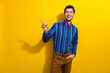 Photo of good mood gentleman dressed striped shirt tie bow directing look at promo empty space isolated on vivid yellow color background