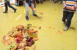 children playing, cleaning up autumn leaves