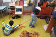children playing, cleaning up autumn leaves