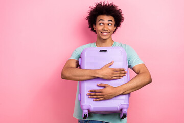 Canvas Print - Photo of funny tricky guy wear blue t-shirt hugging baggage looking empty space isolated pink color background