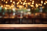 Fototapeta Sport - Food stand with blurred customers dining at a café empty wooden table and background of bokeh lights Ideal for product display online advertising