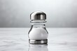 Glass salt shaker on a table with a white background