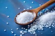 Salty background for advertising with coarse salt crystals and a wooden spoon
