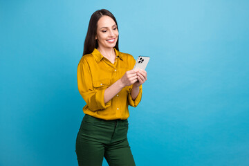 Canvas Print - Photo of confident pretty lady wear yellow shirt communicating modern device empty space isolated blue color background