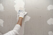 © airdone - Plasterwork and wall painting preparation. close up hand of craftsman applying filling drywall patch.
