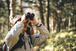 © chokniti - woman family walking in the forest to watching a bird in nature, using binocular for birding by looking on a tree, adventure travel activity in outdoor trekking lifestyle, searching wildlife in jungle