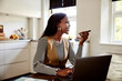 © Flamingo Images - Smiling businesswoman talking on a speaker phone