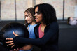 © Flamingo Images - Women exercising with a ball on a gym floor