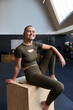 © Flamingo Images - Laughing woman sitting on a box at the gym