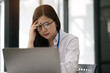 Businesswoman eyestrain fatigued from computer work, stressed women suffer from headache bad vision sight problem sit at office table using computer.