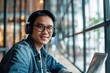 © Attasit - happy smiling Asian student or businessman wearing headphones talking on an online chat meeting using a laptop in an office or campus, Asian male student wearing glasses learning remotely