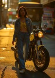 Fototapeta Miasto - Joven asiática estilosa con motocicleta en una calle iluminada por el atardecer