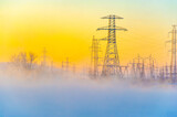 Fototapeta Konie - Beautiful and atmospheric scene of a winter morning. High voltage power lines add an element of power and energy. The misty fog adds a sense of mystery and tranquility.