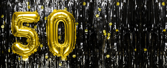 Wall Mural - Gold foil balloon number number 50 on a background of black tinsel decoration. Birthday greeting card, inscription fifty. Anniversary event. Banner.
