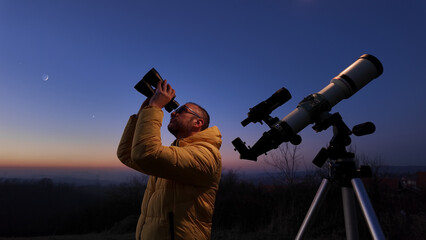 Wall Mural - amateur astronomer looking at the evening skies, observing planets, stars, moon and other celestial 