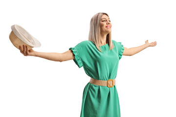 Wall Mural - Young woman holding a straw hat and posing with closed eyes