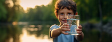 Cute Little Boy With A Glass Of Water On Nature.