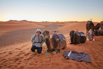 Wall Mural - tourists riding camels, smiling, in the sahara desert