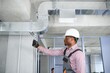 Professional repairman installing air conditioner in a room