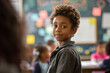 © MNStudio - Cute optimistic child presenting a school project. Little boy during a lesson in classroom. Kid doing homework.